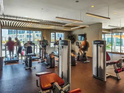 a gym with several people exercising on tread machines at Modern 1BR in Park Heights 2, Dubai Hills in Dubai