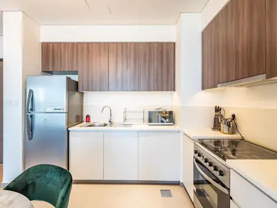 a kitchen with white cabinets and a refrigerator at Modern 1BR in Park Heights 2, Dubai Hills in Dubai