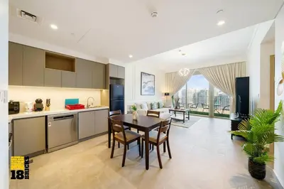 a kitchen and living room with a table and chairs at Brand New 2BR in Creek Harbour in Dubai