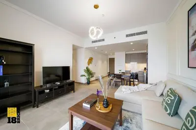 a living room with a white couch and a table at Brand New 2BR in Creek Harbour in Dubai