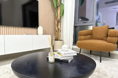 a living room with a coffee table and a chair at Oraya - Suburban Serenity at Spacious 4BR Villa in Maple 2 in Dubai