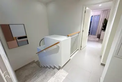 a hallway with a white staircase in a house at Oraya - Suburban Serenity at Spacious 4BR Villa in Maple 2 in Dubai