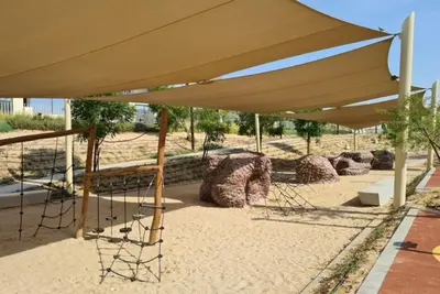 a group of chairs under a large umbrella at Oraya - Suburban Serenity at Spacious 4BR Villa in Maple 2 in Dubai