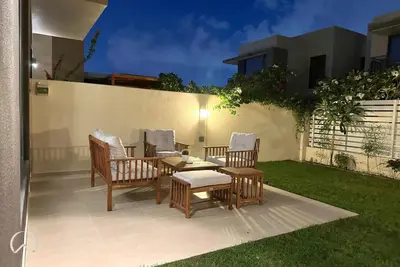 a patio with chairs and a table and a fence at Oraya - Suburban Serenity at Spacious 4BR Villa in Maple 2 in Dubai