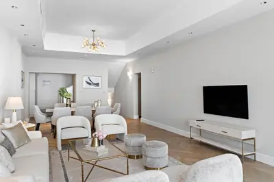 a living room with white furniture and a flat screen tv at Luxury 4BR Townhouse Palm Jumeirah in Dubai