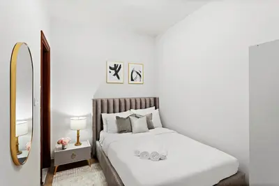 a white bedroom with a large bed and a mirror at Luxury 4BR Townhouse Palm Jumeirah in Dubai