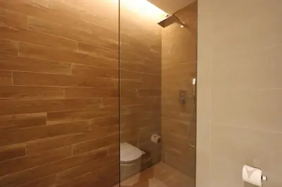 a bathroom with a glass shower with a toilet at Livbnb - Bluewaters 3BR plus Maid's, with Sea Views in Dubai