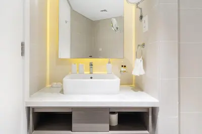 a bathroom with a white sink and a mirror at Damac Maison Prive DVR Vacation Homes in Dubai