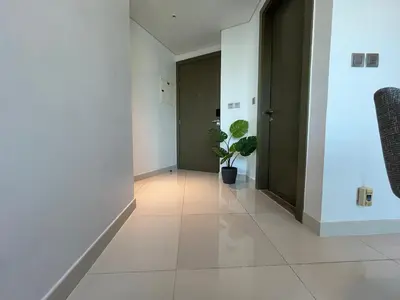 a hallway with white walls and a door and a plant at Damac Maison Prive DVR Vacation Homes in Dubai
