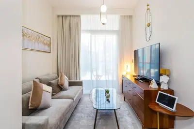 a living room with a couch and a tv at Burj View Apartment at Vera, Business Bay in Dubai