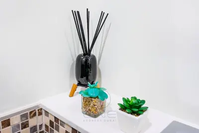 a white counter with two potted plants and a black vase at Burj View Apartment at Vera, Business Bay in Dubai