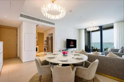 a dining room and living room with a table and chairs at Livbnb Premium 3BR at Address JBR Posh Interiors with Sea and Ain Views in Dubai