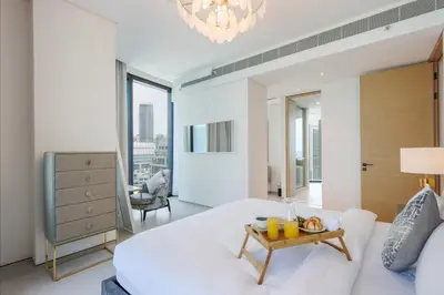 a bedroom with a large white bed and a chandelier at Livbnb Premium 3BR at Address JBR Posh Interiors with Sea and Ain Views in Dubai