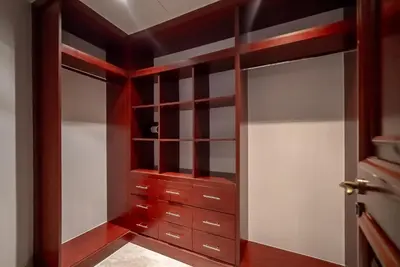 a walk in closet with wooden cabinetry at Stylish Urban Retreat 1BR Gem Fairmont Residence - 90AB2 in Dubai