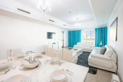 a white living room with a white table and chairs at Stylish Urban Retreat 1BR Gem Fairmont Residence - 90AB2 in Dubai