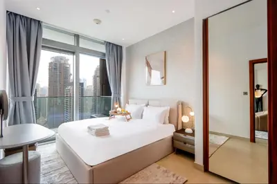 a bedroom with a white bed and a large window at Livbnb Elegant 3BR in Marina Gate Panoramic Marina Views with Private Balcony in Dubai