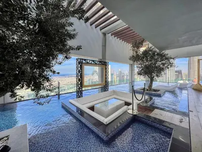 a swimming pool with a table in a building at Dubai Scenic Infinity Pool with Burj Khalifa Views in Dubai