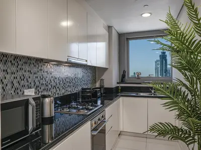 a kitchen with white cabinets and a large window at Dubai Scenic Infinity Pool with Burj Khalifa Views in Dubai