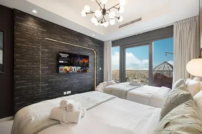 a bedroom with two beds and a tv on a brick wall at Dubai Scenic Infinity Pool with Burj Khalifa Views in Dubai