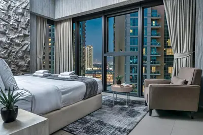 a bedroom with a bed and a large window at Spacious and Overlooking Burj & Fountains in Dubai
