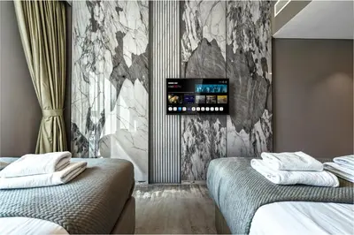 a hotel room with two beds and a tv on the wall at Dubai Mall Connection - Burj Views - Turf Balcony in Dubai