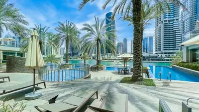a resort with a pool and palm trees at StoneTree - Spacious 1 BR Apartment in Dubai Marina in Dubai