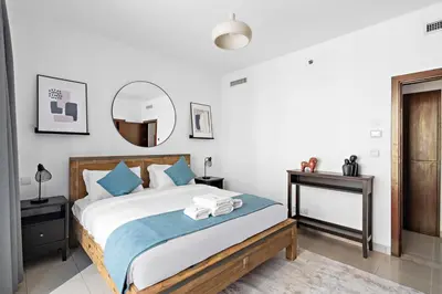 a bedroom with a large bed and a mirror at StoneTree - Spacious 1 BR Apartment in Dubai Marina in Dubai