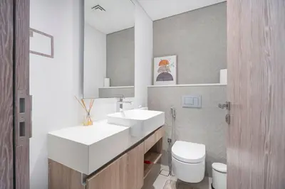 a bathroom with a sink and a toilet and a mirror at NEW Listing - Czechin - JBR Beach a Few Steps Away in Dubai