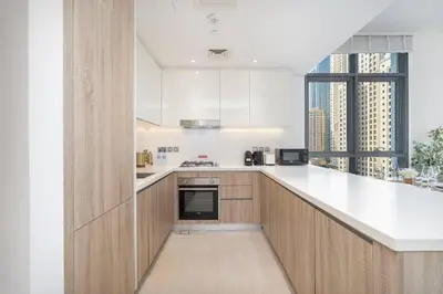 a kitchen with white counters and a large window at NEW Listing - Czechin - JBR Beach a Few Steps Away in Dubai