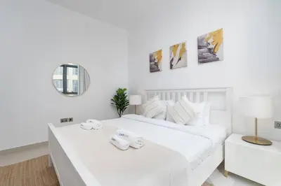 a white bedroom with two white beds and a mirror at NEW Listing - Czechin - JBR Beach a Few Steps Away in Dubai