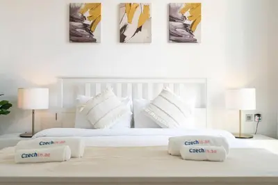 a white bed with two pillows on top of it at NEW Listing - Czechin - JBR Beach a Few Steps Away in Dubai