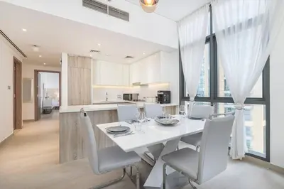 a white dining room with a white table and chairs at NEW Listing - Czechin - JBR Beach a Few Steps Away in Dubai