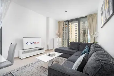 a living room with a couch and a tv at NEW Listing - Czechin - JBR Beach a Few Steps Away in Dubai