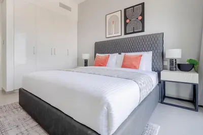 a bedroom with a large white bed with orange pillows at Frank Porter - Downtown Views II in Dubai