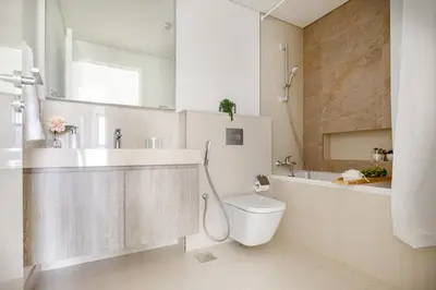 a white bathroom with a toilet and a sink at Frank Porter - Downtown Views II in Dubai