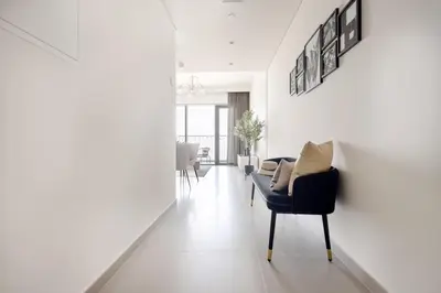 a living room with a black chair and white walls at Frank Porter - Downtown Views II in Dubai