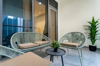 two wicker chairs and a table on a balcony at Urban Elegance new studio near Dubai Mall & Burj in Dubai