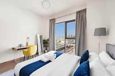 a bedroom with a large bed and a large window at StoneTree - Cozy 1 BR Apartment in Al Furjan in Dubai
