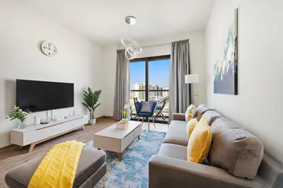 a living room with a couch and a tv at StoneTree - Cozy 1 BR Apartment in Al Furjan in Dubai