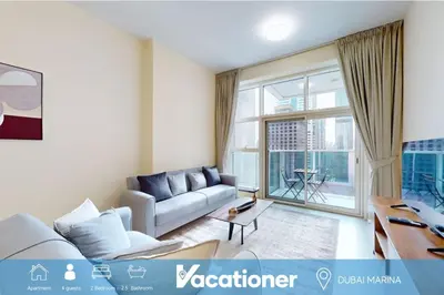 a living room with a couch and a large window at Marina Arcade - Neat Two Bedroom in Dubai