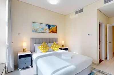 a bedroom with a large white bed with yellow pillows at Marina Arcade - Neat Two Bedroom in Dubai