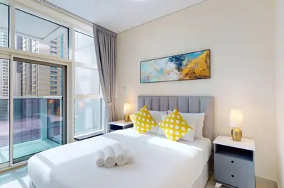 a bedroom with a large white bed and a window at Marina Arcade - Neat Two Bedroom in Dubai