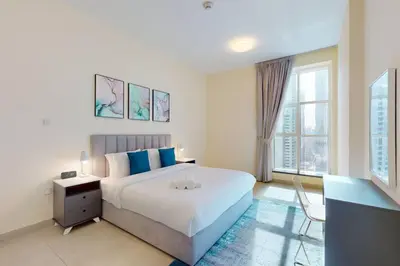 a bedroom with a large bed and a large window at Marina Arcade - Neat Two Bedroom in Dubai