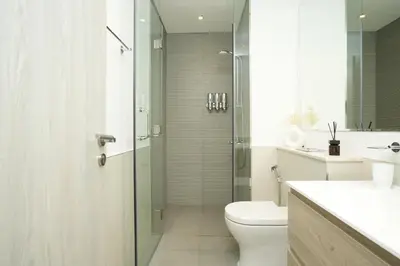 a bathroom with a shower and a toilet and a sink at Cozy Flat in Business Bay in Dubai