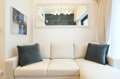 a white couch in a living room with a mirror at Cozy Flat in Business Bay in Dubai