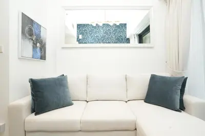 a white couch with blue pillows in a living room at Cozy Flat in Business Bay in Dubai