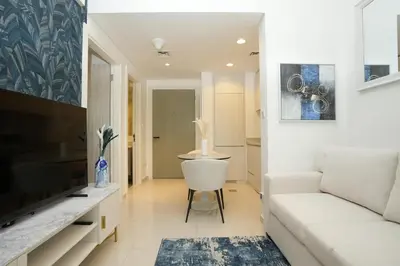 a living room with a white couch and a television at Cozy Flat in Business Bay in Dubai