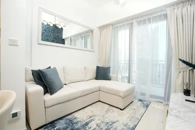 a white living room with a couch and a window at Cozy Flat in Business Bay in Dubai