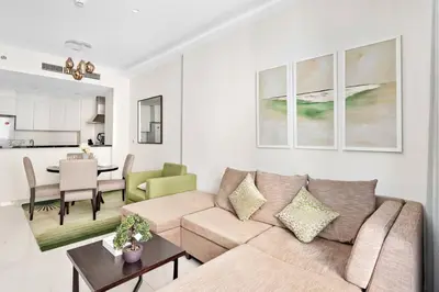 a living room with a couch and a table at StoneTree - Furnished 1BR minutes of drive away to Expo 2020 in Dubai
