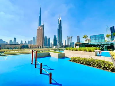 a swimming pool with a city skyline in the background at Downtown Views 1BR - Dubai Mall, Fountain & Burj Khalifa access in Dubai